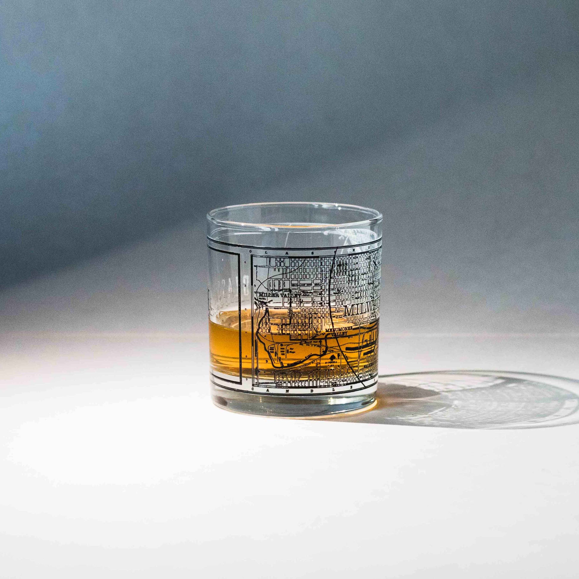 11oz whiskey rocks glass with a screen printed vintage map of Milwaukee filled with whiskey. A Milwaukee Candle Co. and Glassnote Candle Bar collaboration.