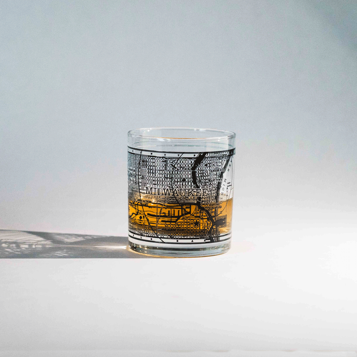 Rotating GIF showing all sides of the 11oz whiskey rocks glass with a screen printed vintage map of Milwaukee. A Milwaukee Candle Co. and Glassnote Candle Bar collaboration.