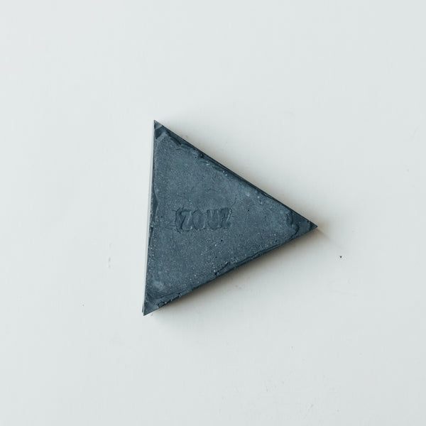 ZOUZ natural incense triangle shaped graphite concrete incense cone burner with “ZOUZ” engraved on the bottom.