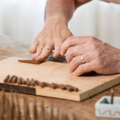 Person hand rolling ZOUZ natural incense cones
