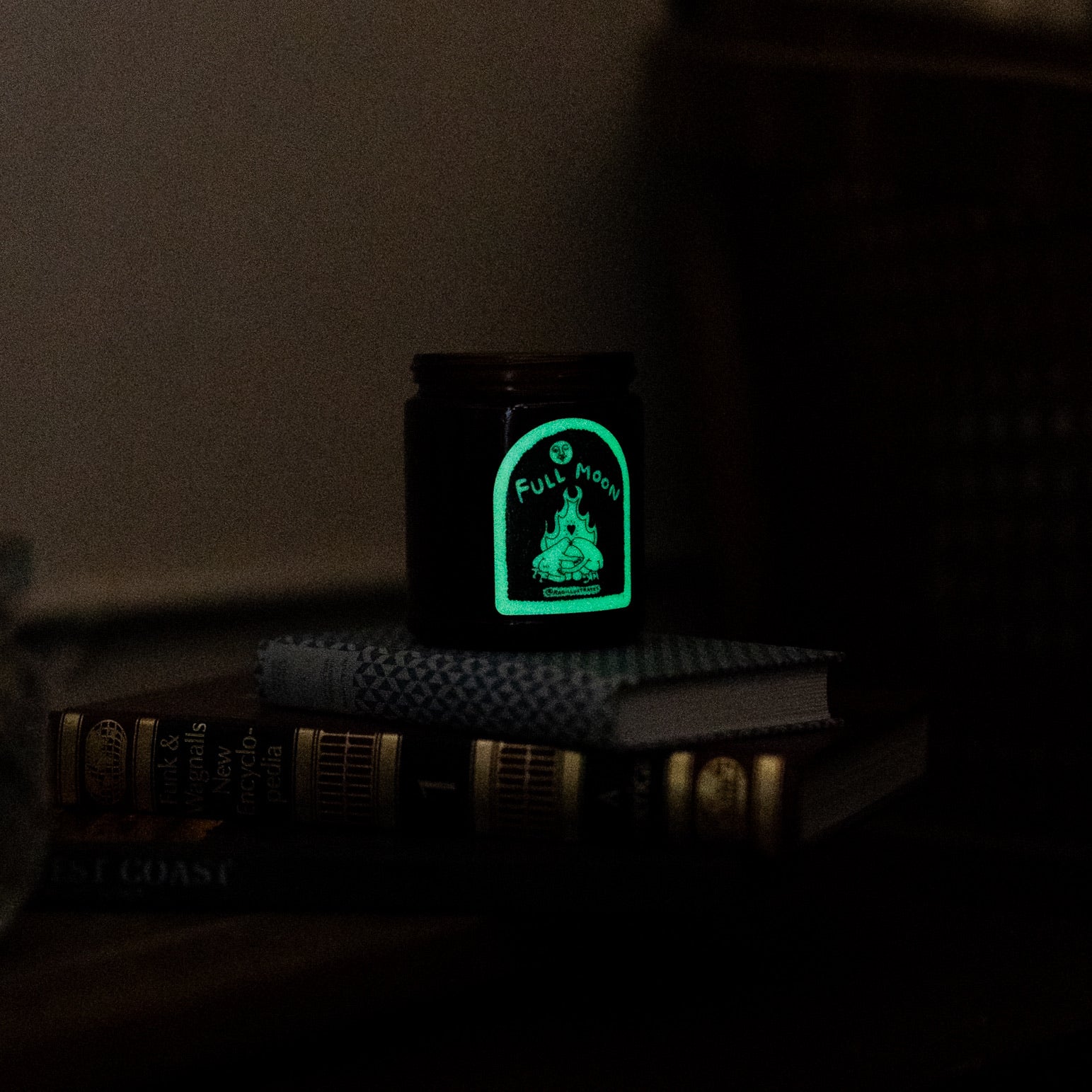 Full Moon Candle on a stack of books glow in the dark