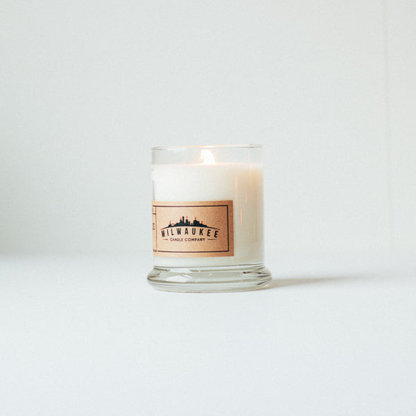 Lit 12 ounce soy wax candle with kraft paper label.