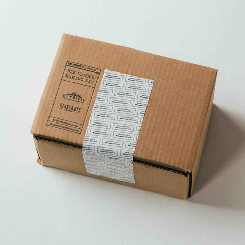 DIY candle making kit packaged in cardboard box with a Glassnote stamp secured with patterned Milwaukee Candle Co branded tape