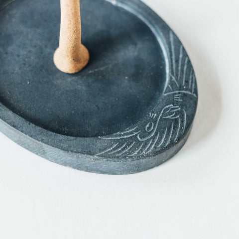 close up of oval shaped gray concrete ZOUZ natural incense handmade burner with engraved bird design