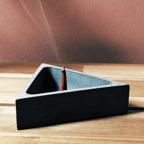 ZOUZ natural incense cone burning in a triangle shaped incense burner