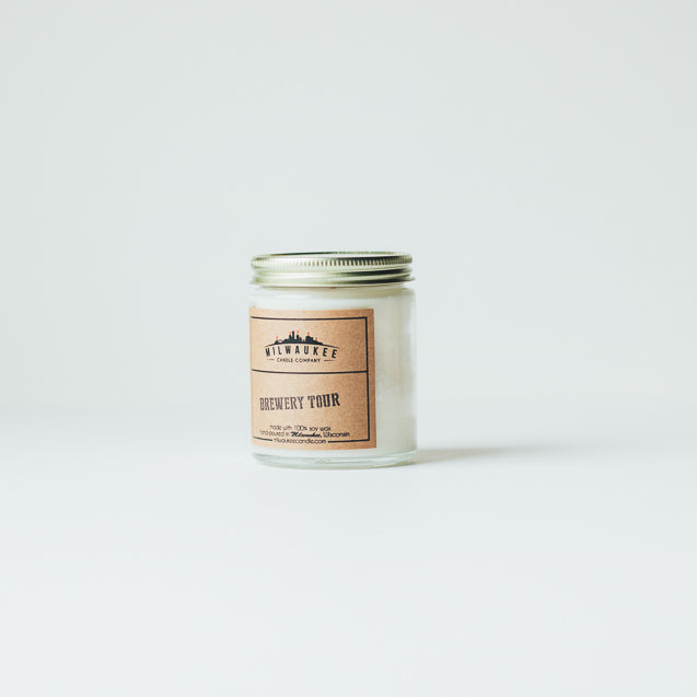 6 ounce Brewery Tour clear jar soy wax candle with kraft paper label and gold lid. Hand-poured in Milwaukee, Wisconsin.