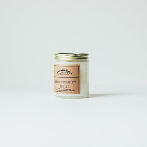6 ounce ButterCream City Vanilla clear jar soy wax candle with kraft paper label and gold lid. Hand-poured in Milwaukee, Wisconsin.