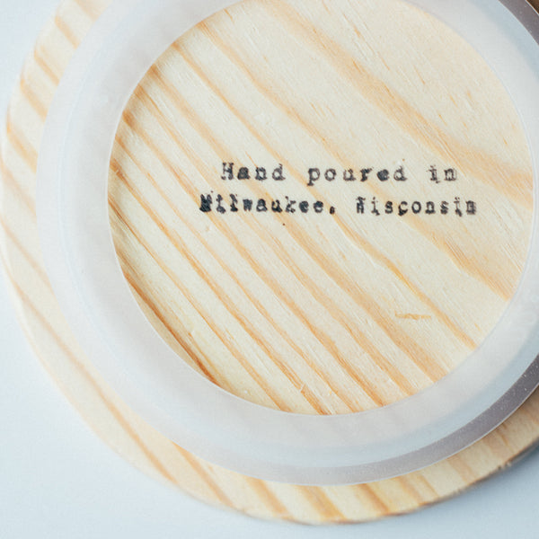 Close up of wooden lid stamped with the text "Hand-poured in Milwaukee, Wisconsin."