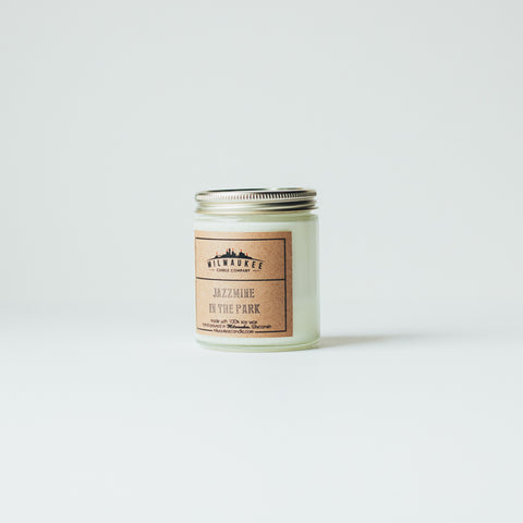 6 ounce Jazzmine in the Park clear jar soy wax candle with kraft paper label and gold lid. Hand-poured in Milwaukee, Wisconsin.