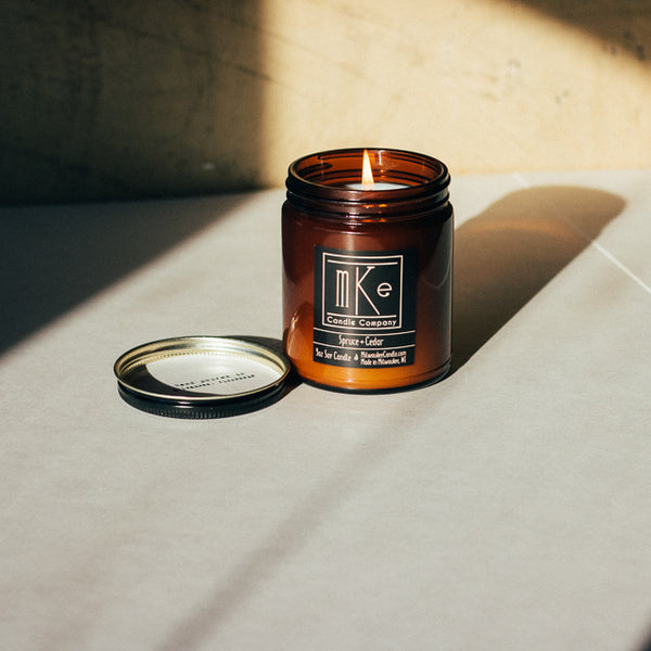 Lit 9 ounce Spruce and Cedar amber jar soy candle