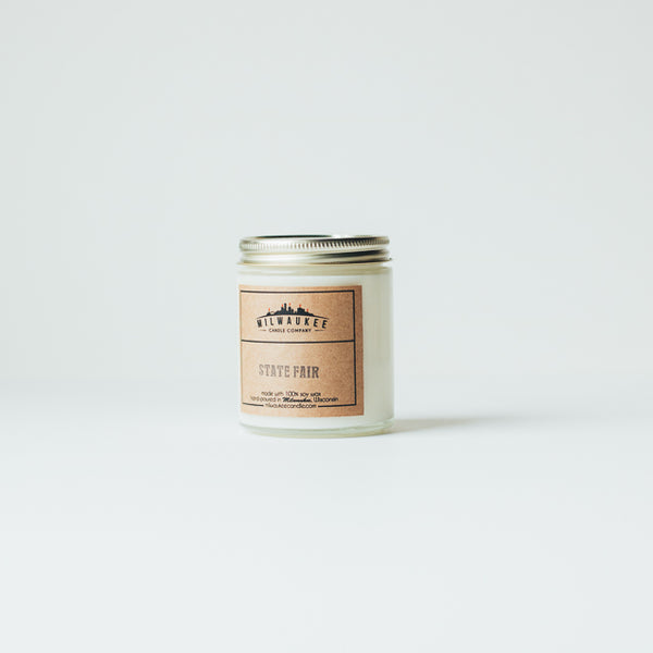 6 ounce State Fair clear jar soy wax candle with kraft paper label and gold lid. Hand-poured in Milwaukee, Wisconsin.